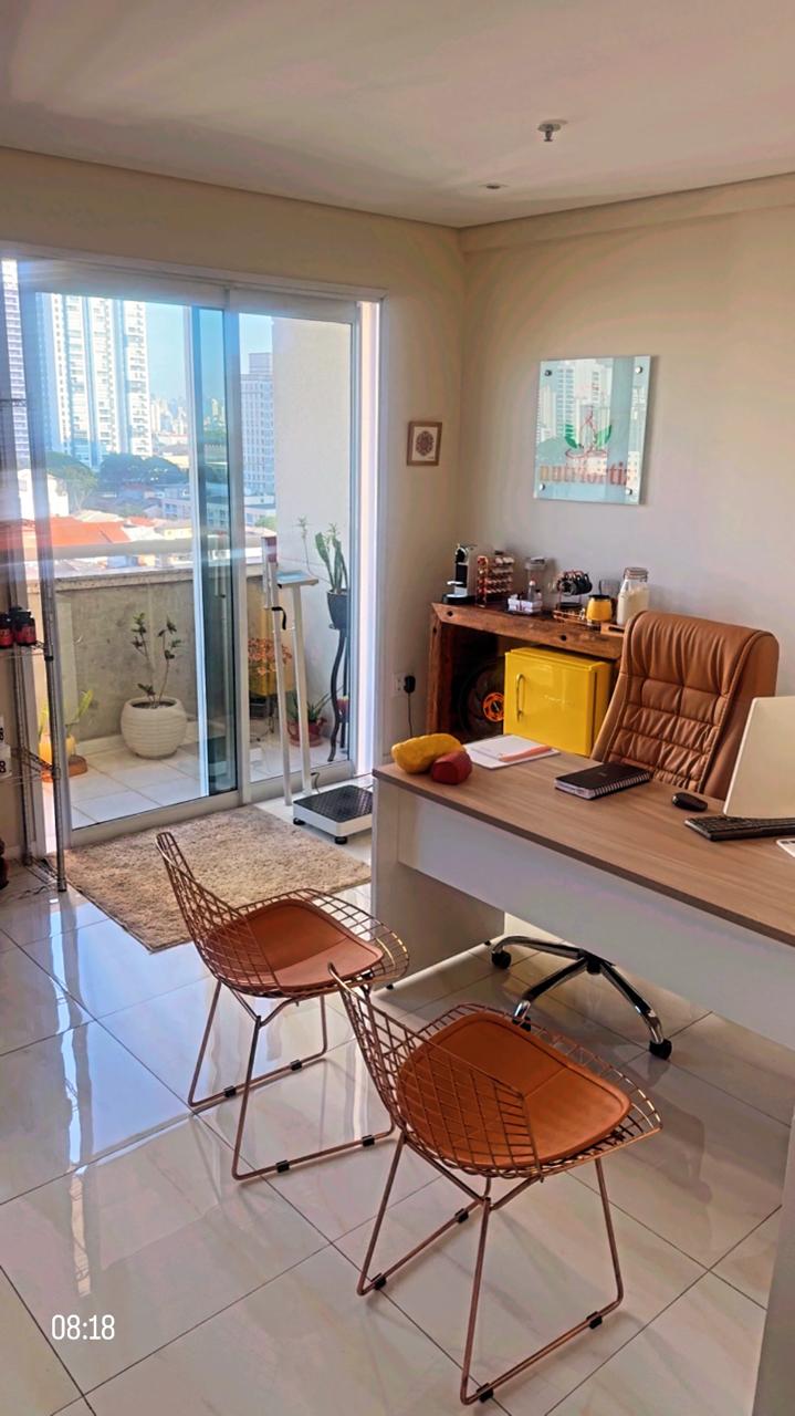 Interior do consultório Nutriortiz: mesa de atendimento com vista para a varanda e logo na parede