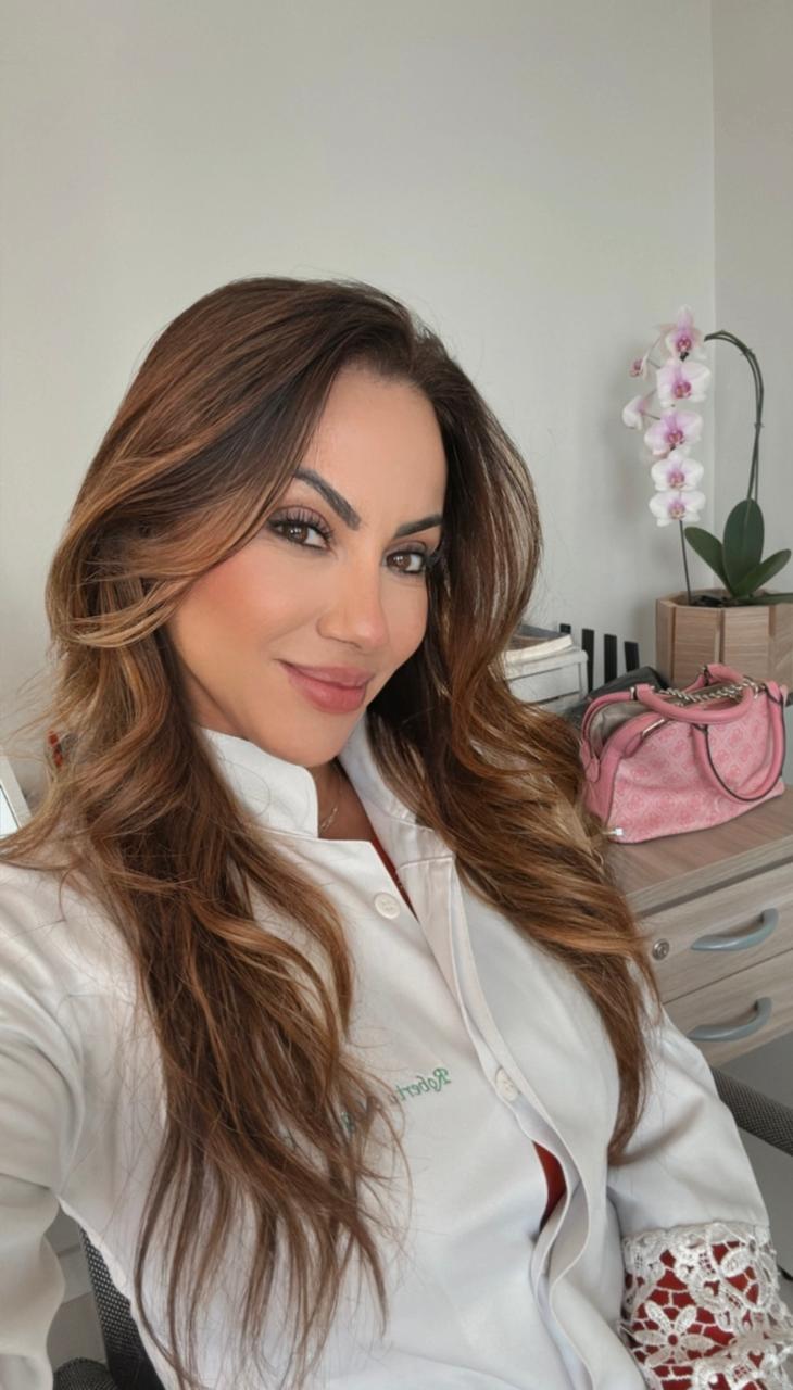 Dra. Roberta Nogales Ortiz de jaleco branco no consultório